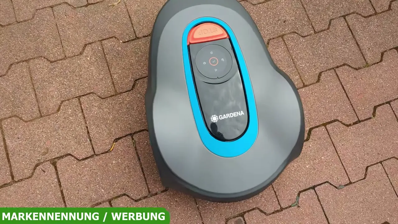 Auf der Oberseite liegen die Bedientasten sowie der auffällige Stopp-Knopf zum sofortigen Anhalten des Mähers.